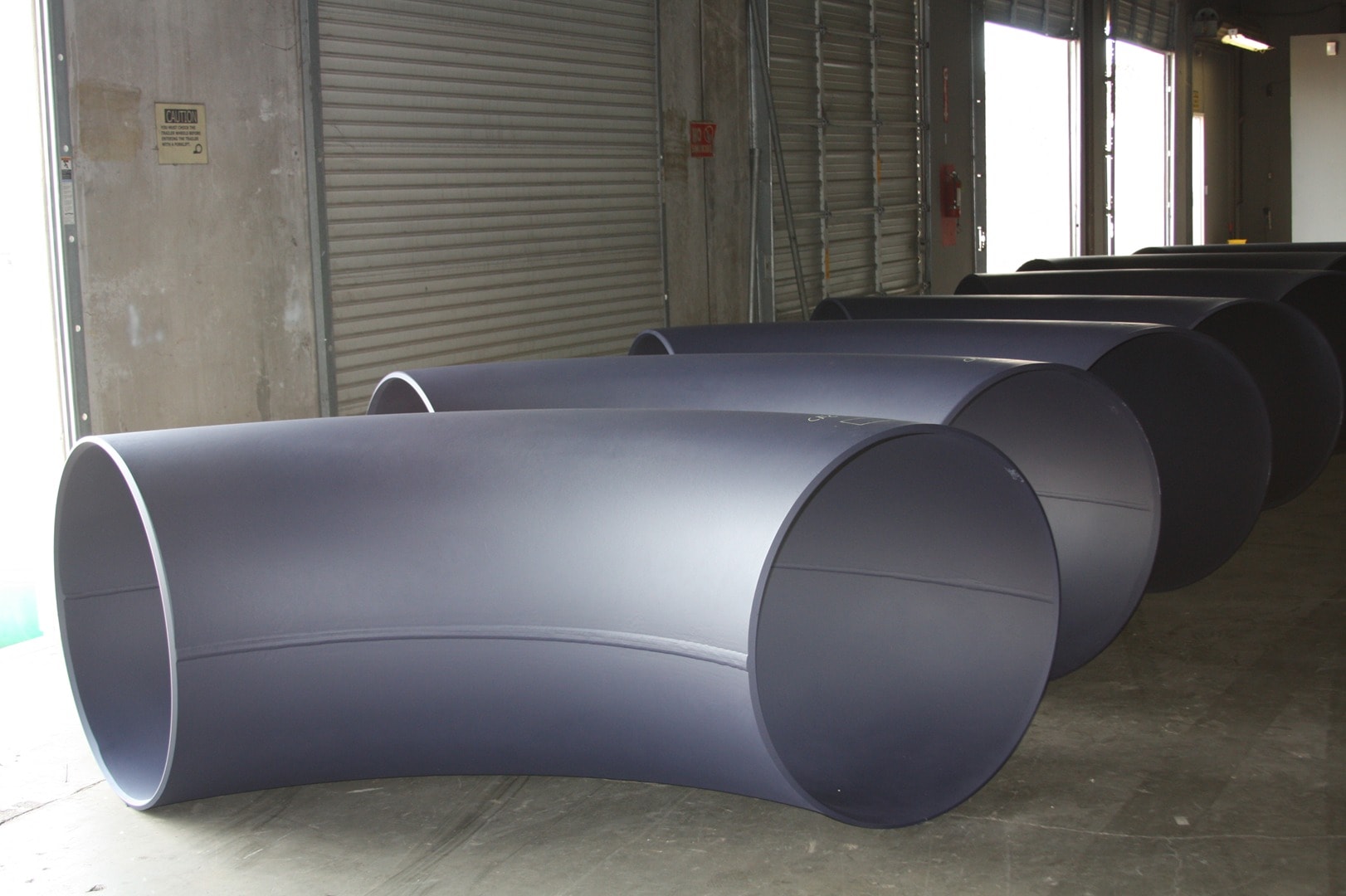Industrial warehouse interior with large pipes stored diagonally